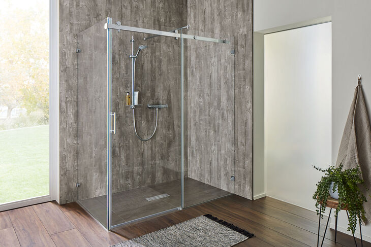 SPRINZ Opalin S Moderner Duschbereich mit grauen Holzfliesen und begehbarer Dusche Opalin S von SPRINZ. Eine fixe Glaswand trifft auf eine Gleittür-Konstruktion, die die Glastür sanft zur Seite rollen lässt.