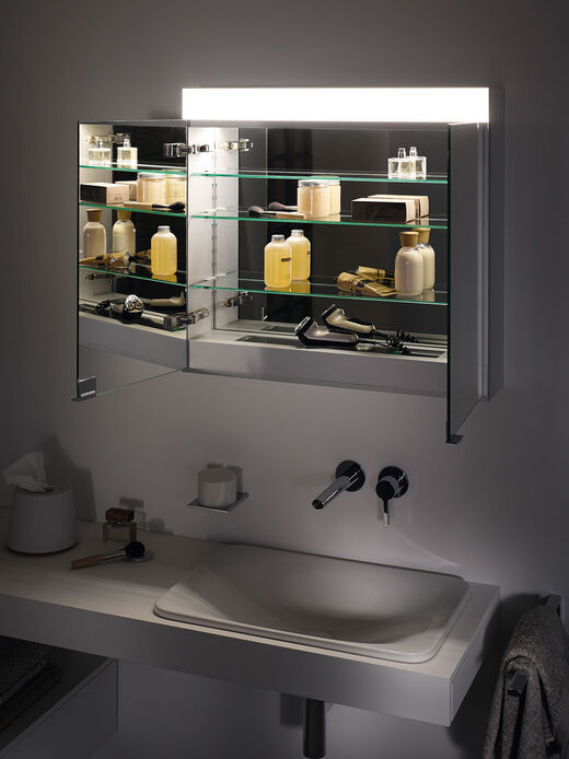 Spiegelschrank geöffnet bei Nacht mit eingeschalteter Beleuchtung von KEUCO aus der Edition 400. Doppelt verspiegelte Türen, dimmbares Licht und Spiegelheizung.