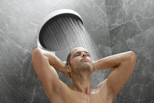 hansgrohe Rainfinity PowderRain Wie ein Sommerregen: Mann genießt den Powderrain-Strahl unter der Rainfinity Kopfbrause von hansgrohe.