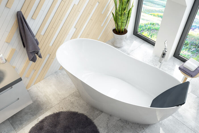 Badewanne mit Nackenkissen freistehend oval in modernem Badezimmer mit Grünpflanzen.