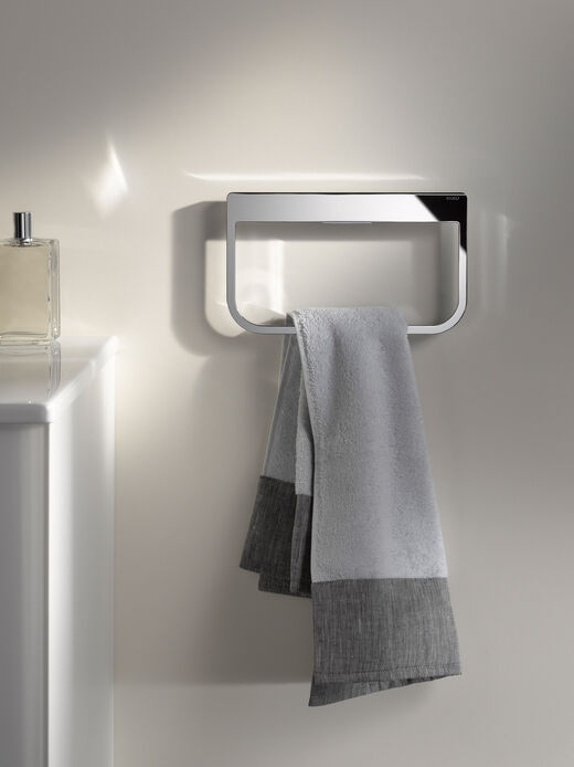 Handtuchhalter chrom an der Wand angebracht mit grauem Handtuch.