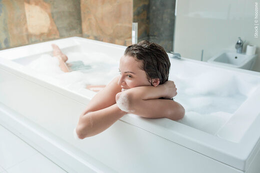 Lachende Frau in einer rechteckigen Badewanne – Modelbild von SYR.