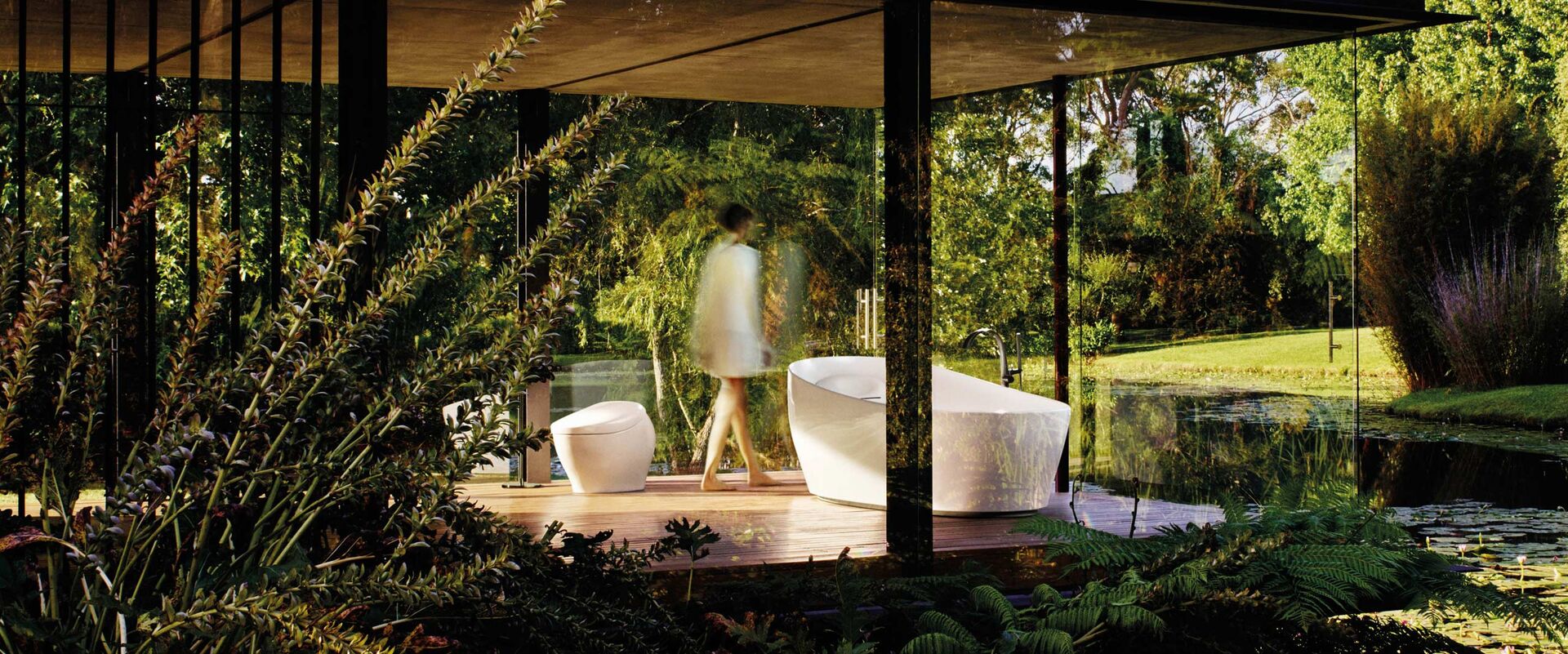 Blick Badezimmer. Verglast im Grünen. Badewanne und Stand-Toilette.