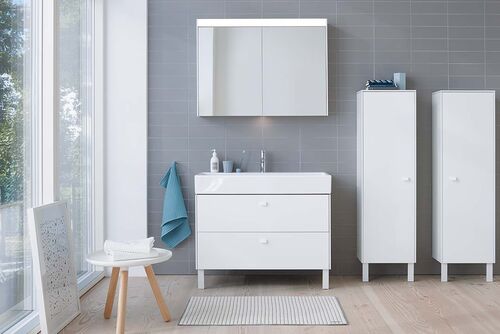 Heller Waschplatz mit seitlichen Schränken, einem Spiegelschrank und Waschplatz mit Aufsatzwaschbecken und Unterschrank mit Schubladen.
