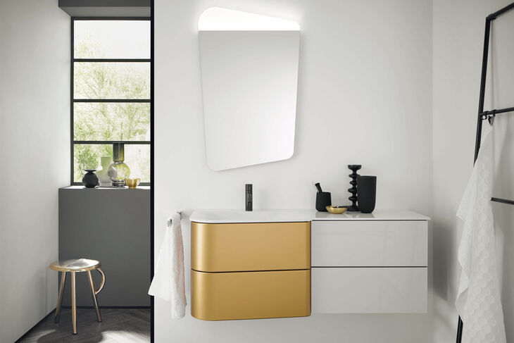 Ein Waschbeckenunterschrank in den Farben Weiss und Gold der Serie Badu von burgbad. 