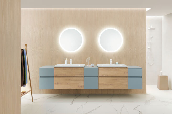 Die grifflose Badmöbelkollektion Lin20 von burgbad kombiniert mit runden Leuchtspiegeln