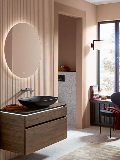 Der mattschwarze Waschtisch aus der Loop & Friends Badserie von Villeroy & Boch passt optimal in ein modern gestaltetes Badezimmer mit großem Spiegel und Holzmöbeln. 