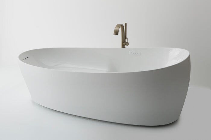 Grosse freistehende Badewanne mit Standarmatur in Gold.