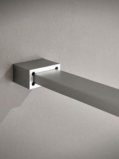 Geometrisches Design: Der eckige Wandanschluss der Haltestange zu ColorStar von Sprinz. Diese Stange fixiert die freistehenden Glaswand zur offenen Walk-In-Dusche.