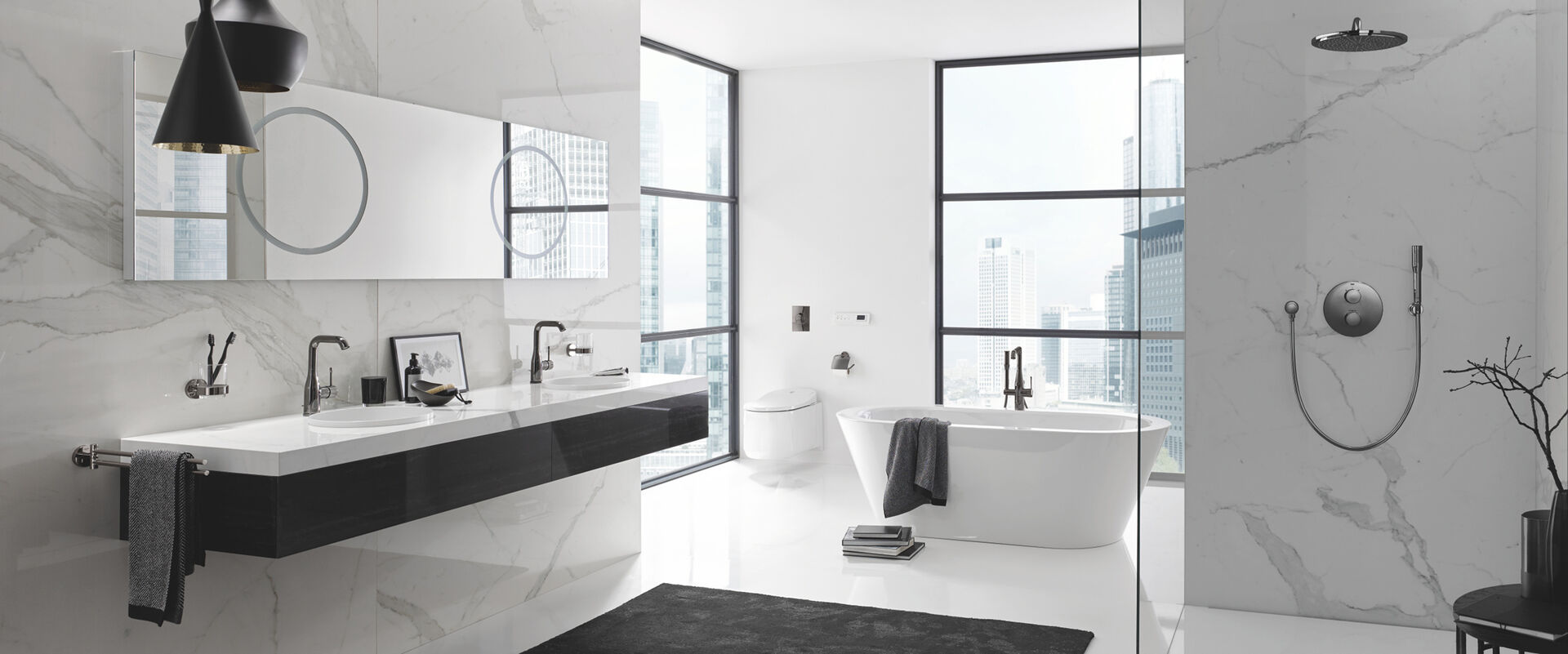 Helles Badezimmer mit Grohe Essence Colours, die an Waschbecken, Badewanne und Dusche installiert sind. Über dem Waschbeckenelement hängen Spiegel.