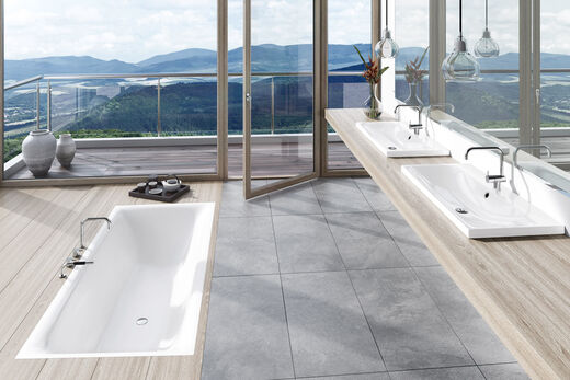Kaldewei Silenio Offenes Badezimmer mit Badewanne in Holzboden eingebaut und zwei Waschbecken seitlich.