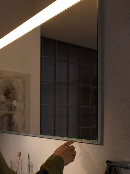 Moderne Lichtspiegel im Bad lassen sich individuell auf den Nutzer und die gewünschte Tätigkeit am Waschplatz einstellen - wie hier der Spiegel Edition 400 von Keuco mit Tastenfeld zur Bedienung.