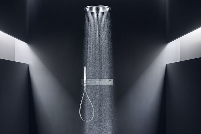 Elegant-Schwarz gehaltenes Badezimmer, an dessen Decke eine Axor Showers Kopfbrause installiert ist. Links und Rechts sorgen Lichtschächte für eine geheimnisvolle Stimmung.