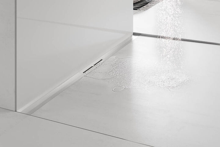 Duschfläche mit der Duschrinne Tecedrainprofil von TECE, in die gerade Wasser fließt.