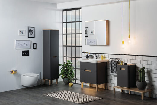 VitrA Sento Badezimmer von VitrA, das neben WC mit den eleganten Santo Badmöbeln ausgestattet wurde. Die Möbelfronten sind dunkel, das Ambiente mit Wandlampe dezent beleuchtet.