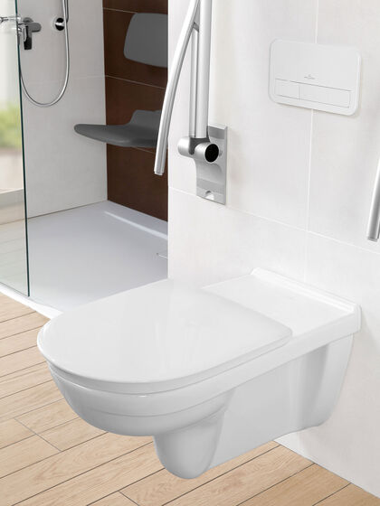 Wand-WC mit längerer Ausladung und einem nach oben geklappten Haltegriff für Personen mit Handicap aus der Serie ViCare von Villeroy & Boch.