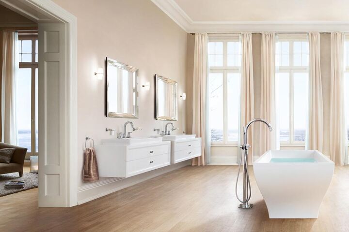 Runde Badaramturen am Doppelwaschtisch mit beleuchteten Badspiegeln und einer freistehenden Badewanne.