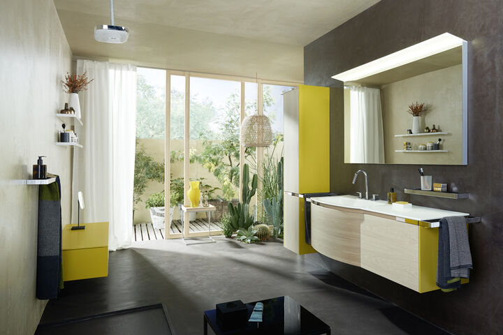 Die Badmöbel yso von burgbad sind in eckiger oder in abgerundeter Formgebung erhältlich. Das Badezimmer besticht durch warme Farben in Dekor Eiche und gelb.