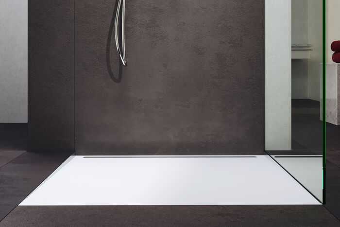 In grau gehaltenes Badezimmer, in dessen Dusche eine Kaldewei Nexys Duschfläche in weißer Farbe eingelassen ist.