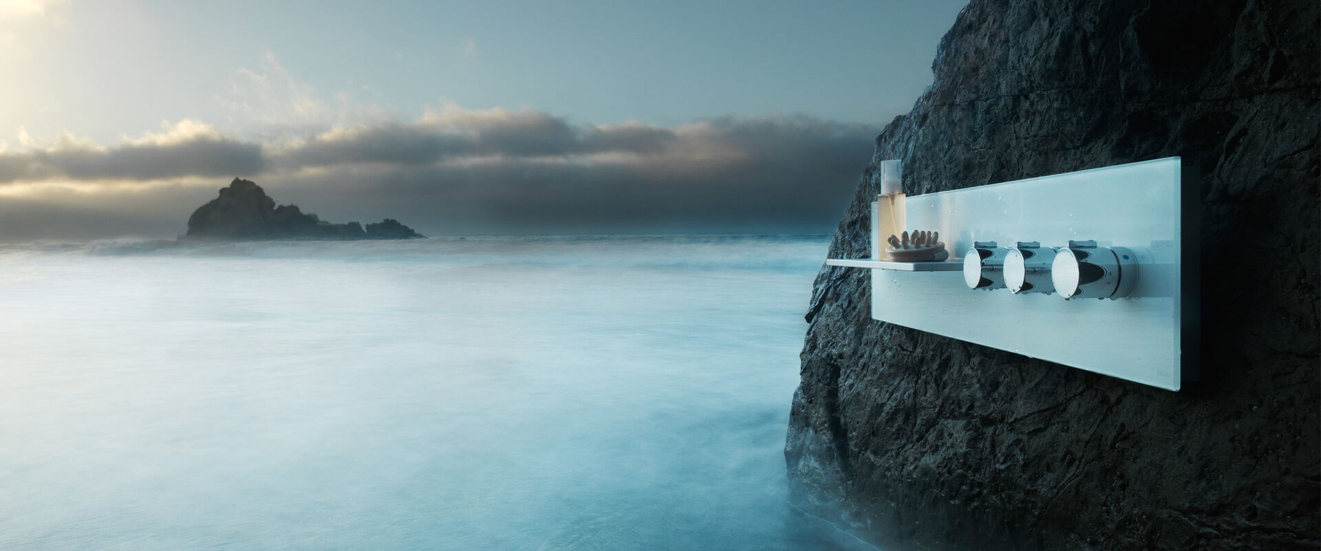 Stimmungsvolle Naturaufnahme von Meer, Brandung, Nebel, Felsen und Wolken. Überraschendes Detail: hier ist die neue Duscharmatur KEUCO meTime_spa auf einem Felsen montiert.