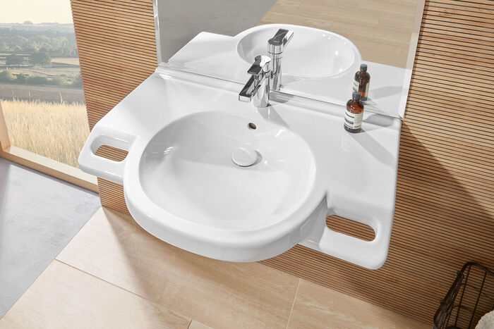 Spezielles Waschbecken für Menschen mit Handicap: zwei Griffe links und rechts erleichtern das Aufstehen, zum Beispiel, wenn man sich zum Waschen hingesetzt hat.