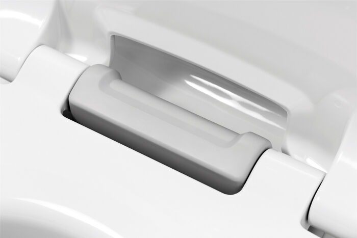 Der Haromed WC-Sitz von Hamberger bietet besonderen Komfort: Großaufnahme des Haltegriffes in Farbe Grau zwischen den Scharnieren. Weitere Farben wählbar.