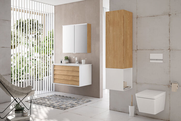 Helles Badezimmer mit einem Waschplatz in Holz und weisser Badkeramik. Hochschrank neben Toilette.
