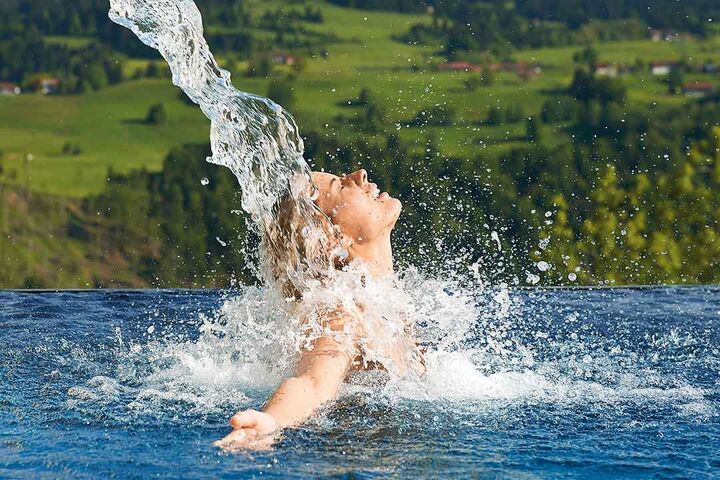 Splashiges Model unter einem Wasserschwall in freier Natur.