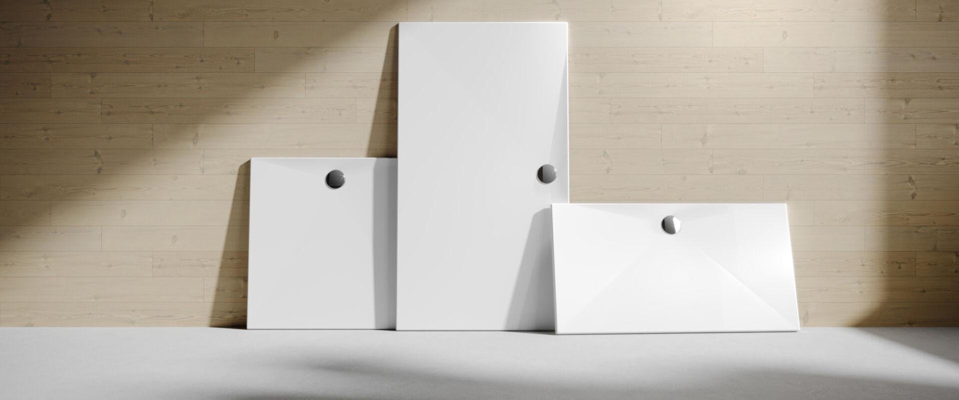 Die weiße Duschfläche EasyStep von HÜPPE mit einem chromfarbenen Ablauf lehnt in drei verschiedenen Größen an einer Holzwand. 