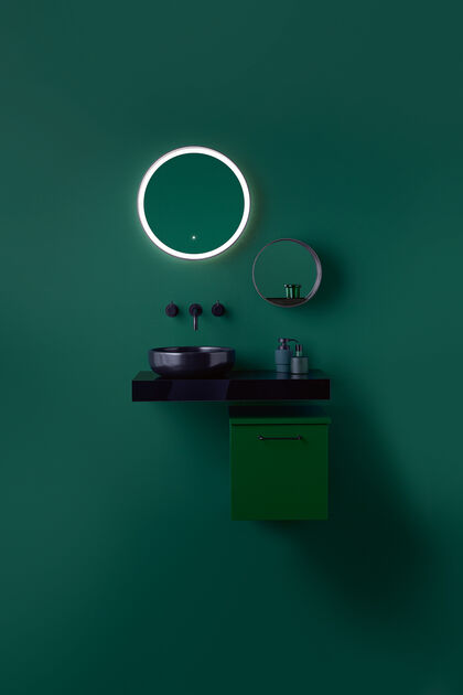 Grüne Waschtischkombi, bestehend aus Unterschrank, Waschtisch, der dann der Wand montiert ist, Aufsatzwaschbecken und Armaturen in schwarz sowie Spiegeln an der Wand.