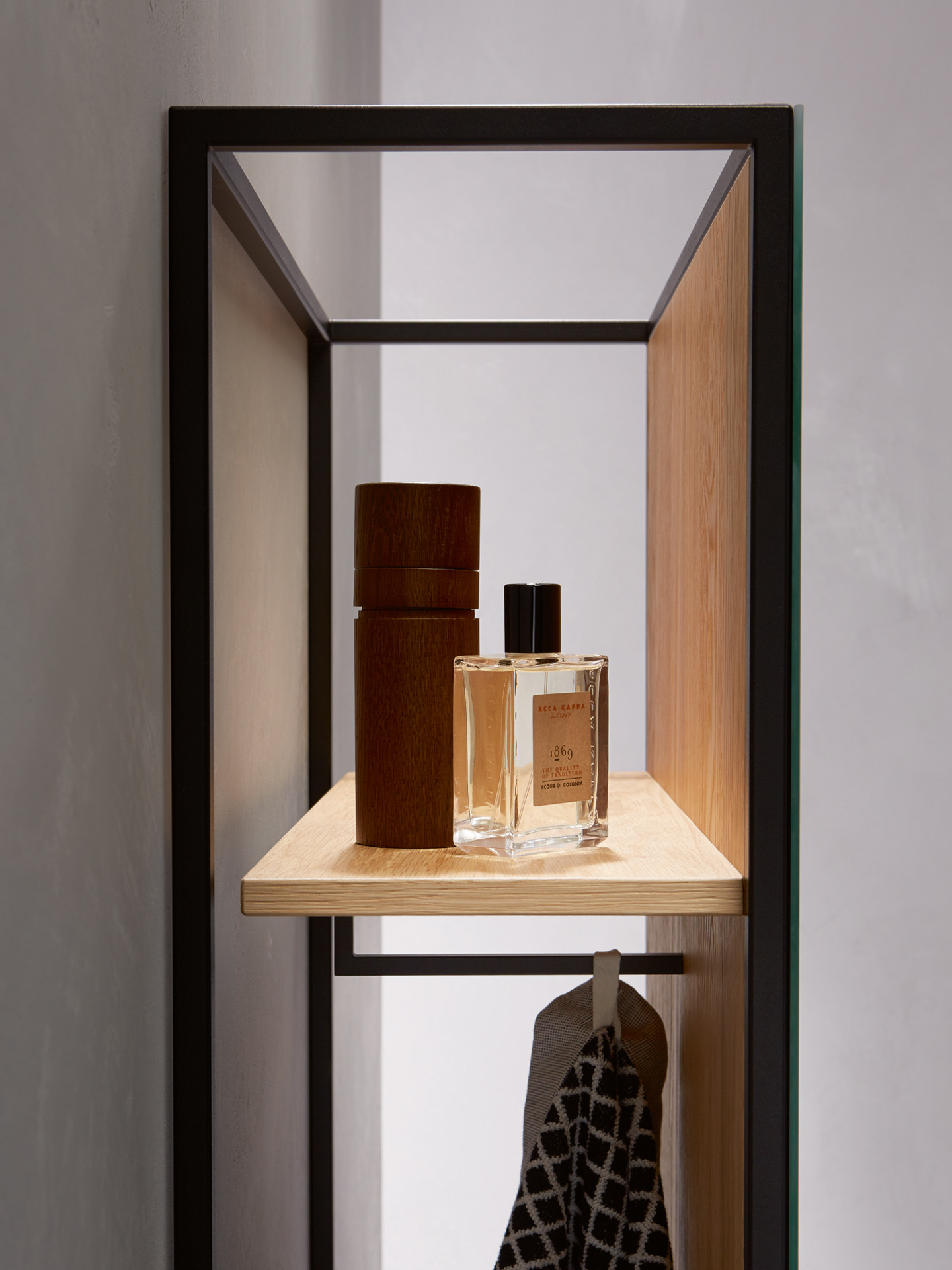 Seitlicher Einblick in Badezimmerschrank mit schwarzem Stahlgestell und Holzablage.