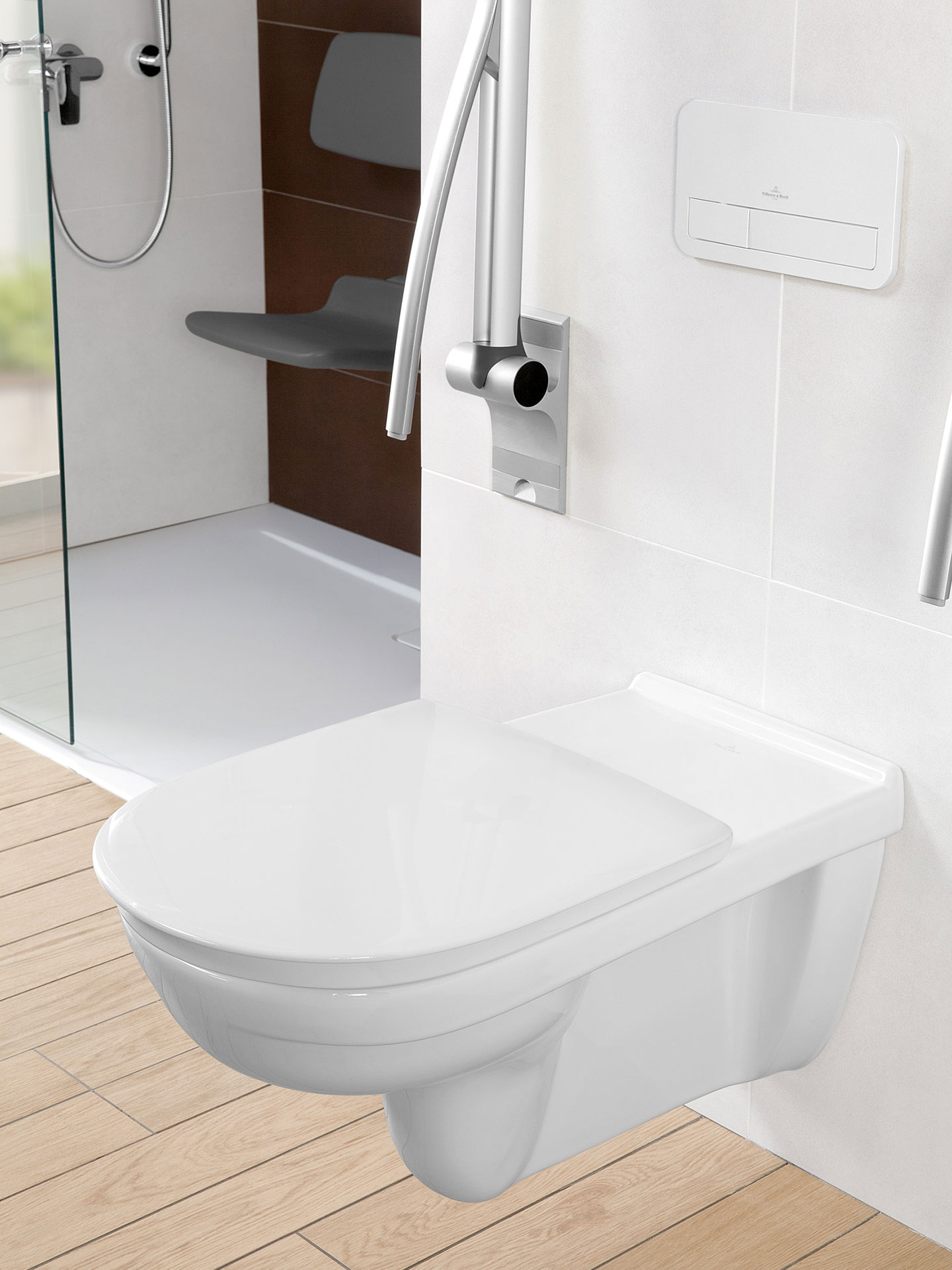 Wand-WC mit längerer Ausladung und einem nach oben geklappten Haltegriff für Personen mit Handicap aus der Serie ViCare von Villeroy & Boch.