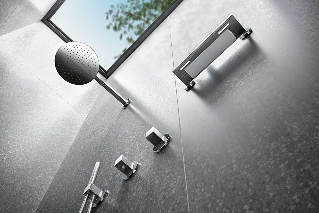 Steile Perspektive von unten in einer Dusche nach oben fotografiert. Man sieht Brausekopf, Brausearmatur, Handbrause und Duschkorb von unten aus Edition 90 von Keuco.
