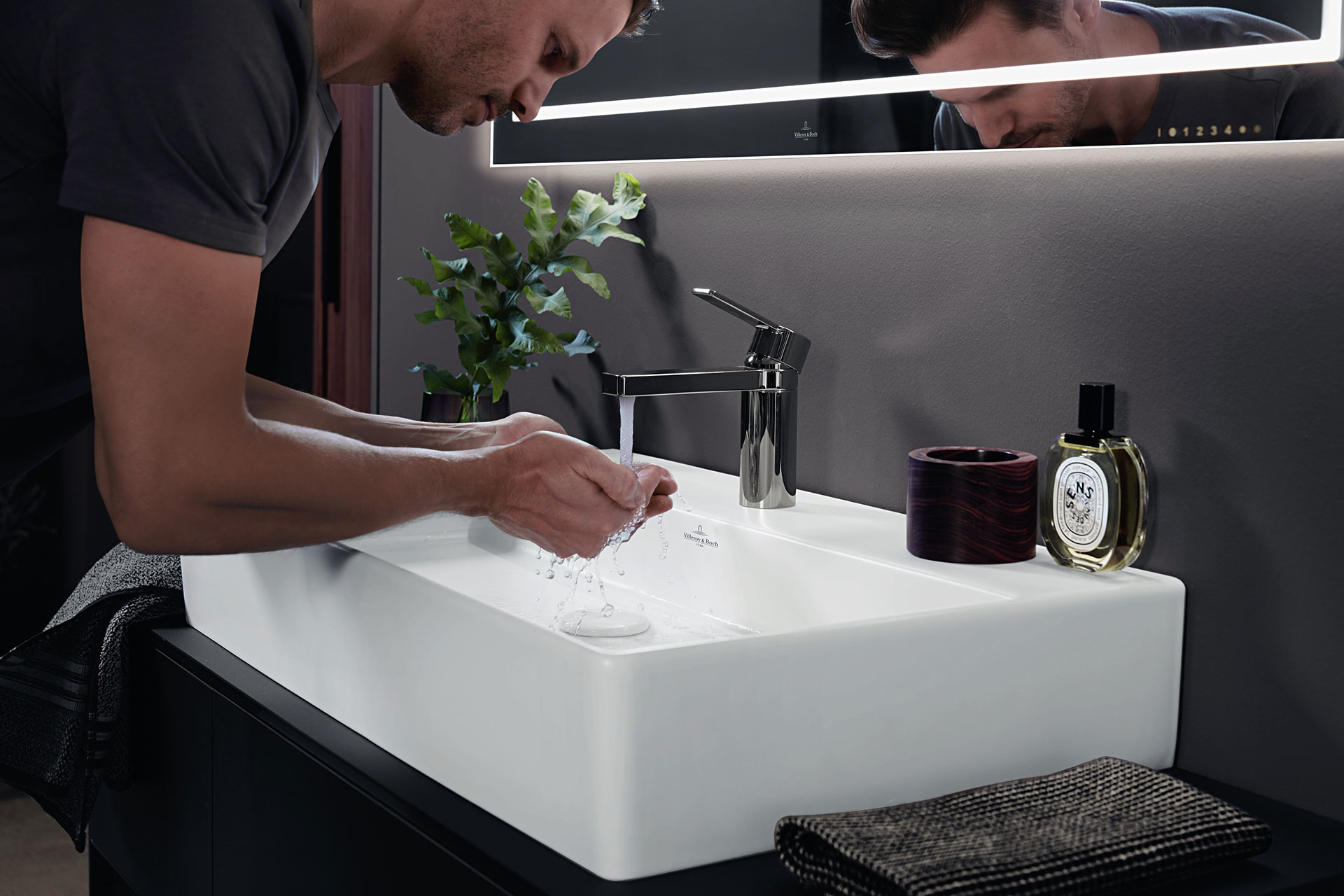 Großaufnahme eines Mannes über den Waschtisch gebeugt beim Händewaschen in einem Memento 2.0 Keramik-Waschbecken von Villeroy & Boch.