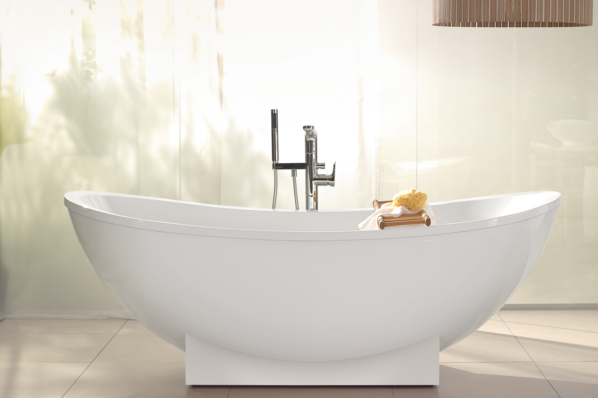 Badewanne aus Quaryl oval auf weissem Sockel freistehend.