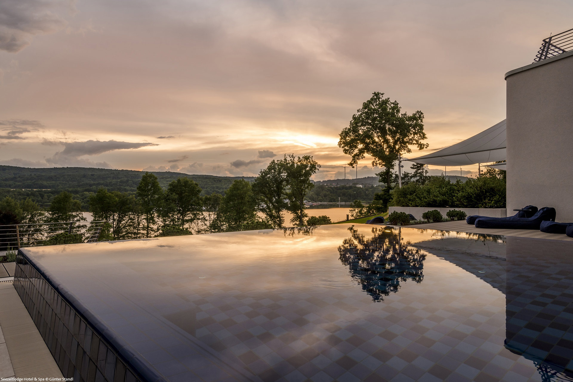 Pool der Seezeitlodge im Abendrot mit Blick auf den Bostalsee.